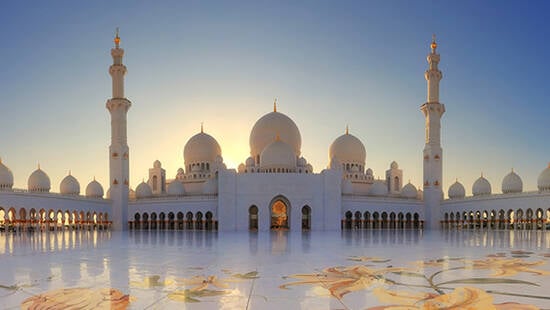 The Sheikh Zayed Grand Mosque standing in front of the rising sun