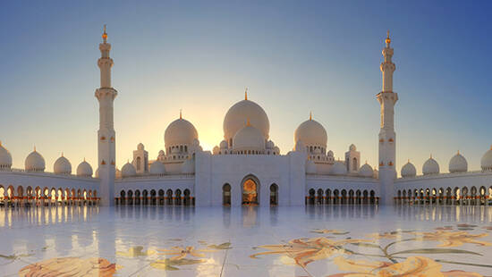 The Sheikh Zayed Grand Mosque standing in front of the rising sun