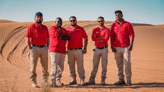 Arabian Adventure team with their white vehicles in the desert