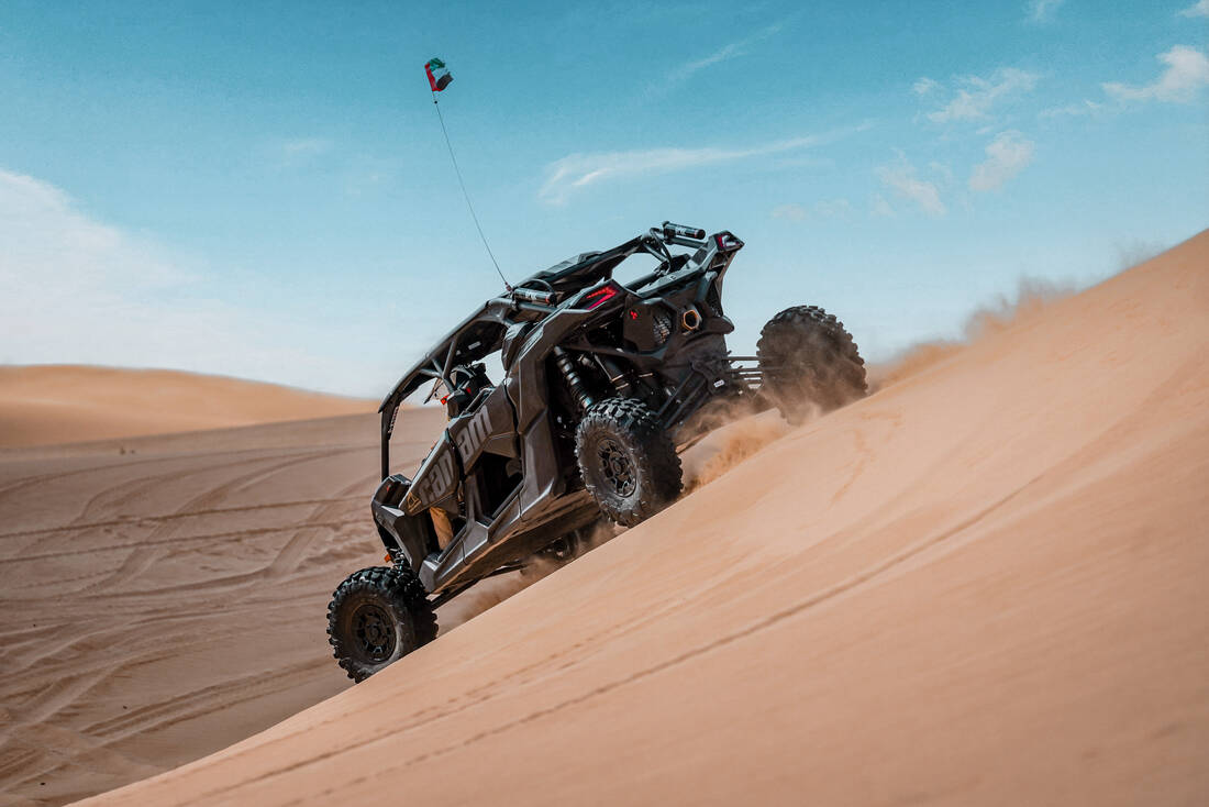 black dune buggy going down a sand dune
