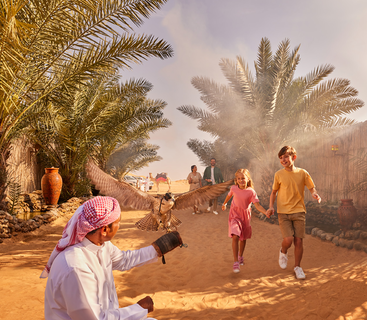 kids running through the entrance of a safari camp towards a made dressed in local attire in the corner holding a falcon