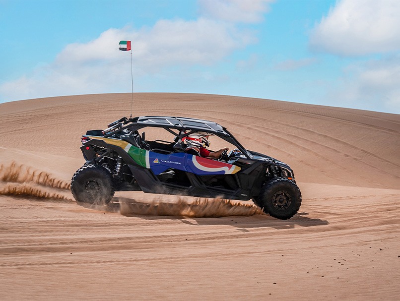 An Arabian Adventures dune buggy driving across a sand dune