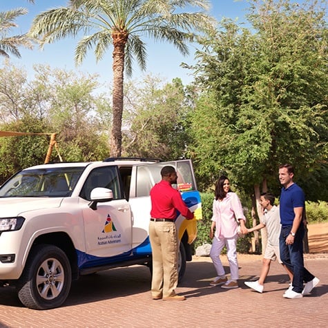 An Arabian Adventures representative picking up a family with an Arabian Adventures 4 wheel vehicle