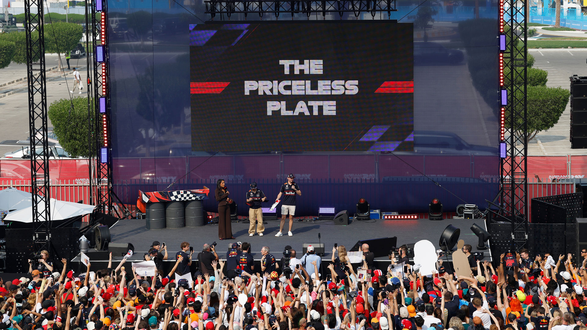 Fans in front of a staging with 3 hosts and text displayed about The Priceless Plate