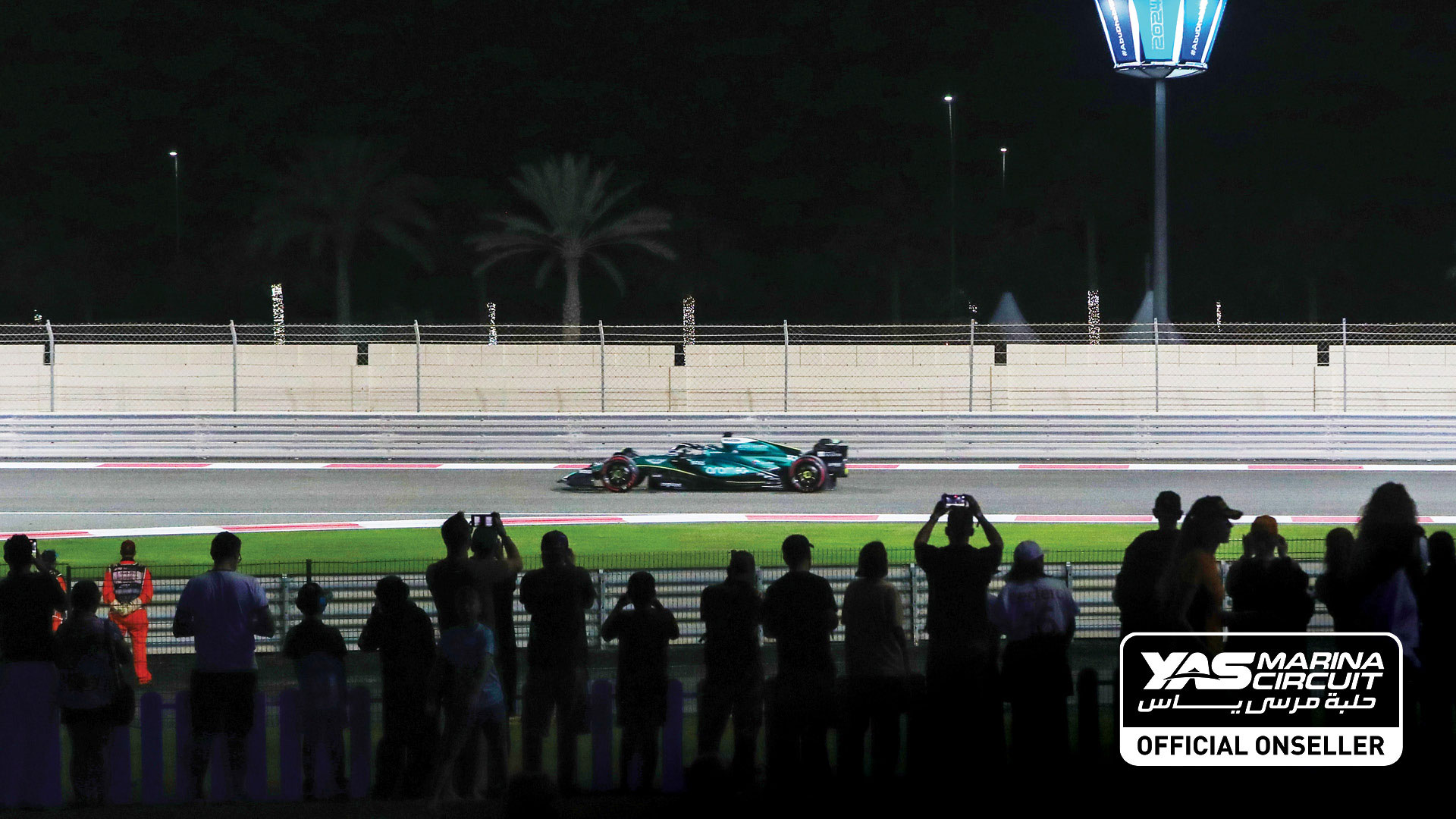 Shot of fan silhouettes cheering for a blue F1 race car
