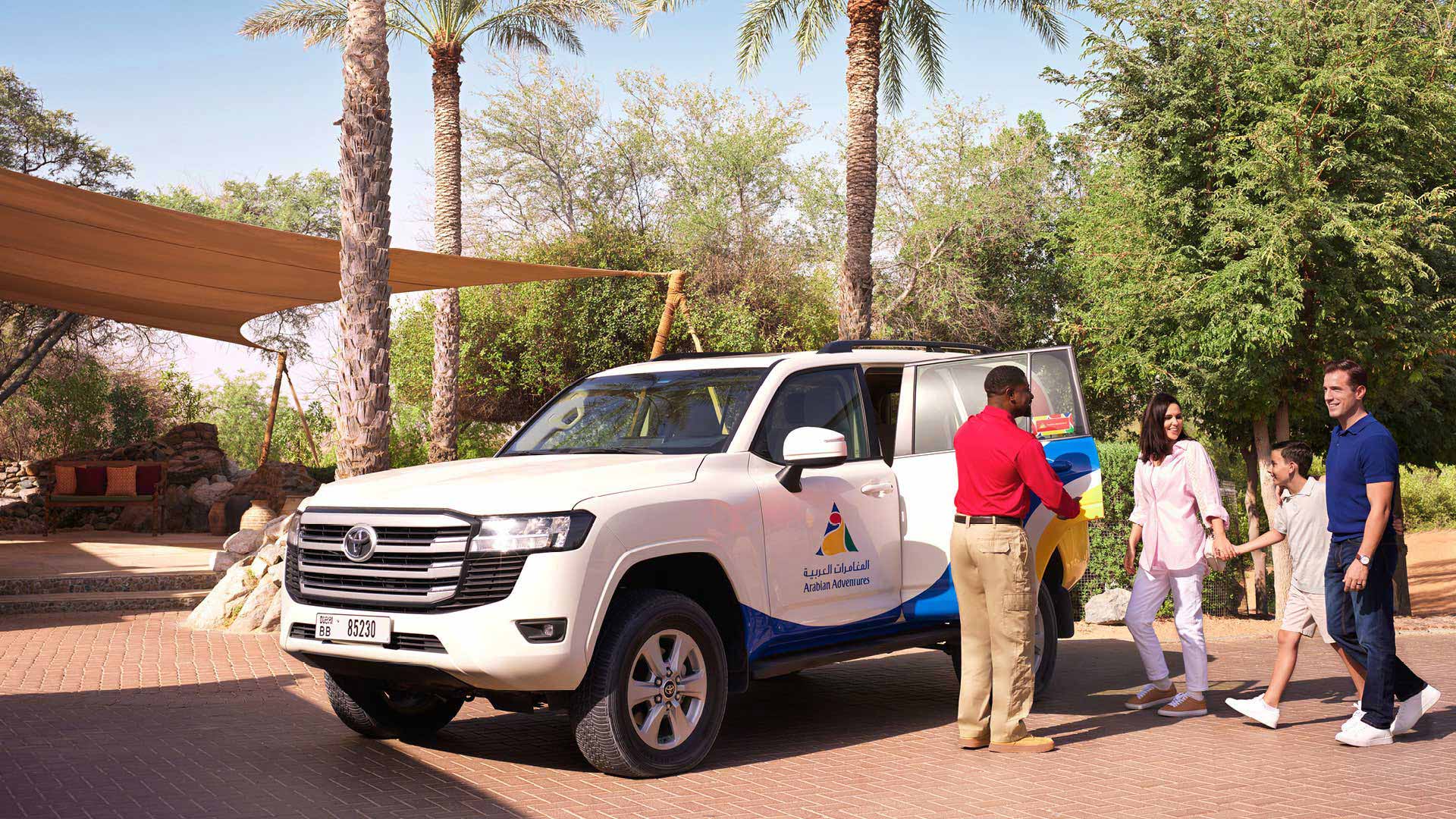 An Arabian Adventures representative picking up a family with an Arabian Adventures 4 wheel vehicle