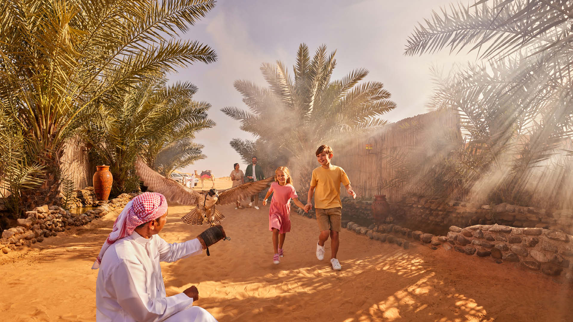 Two kids running towards a man holding up a falcon at the entrance of a desert camp